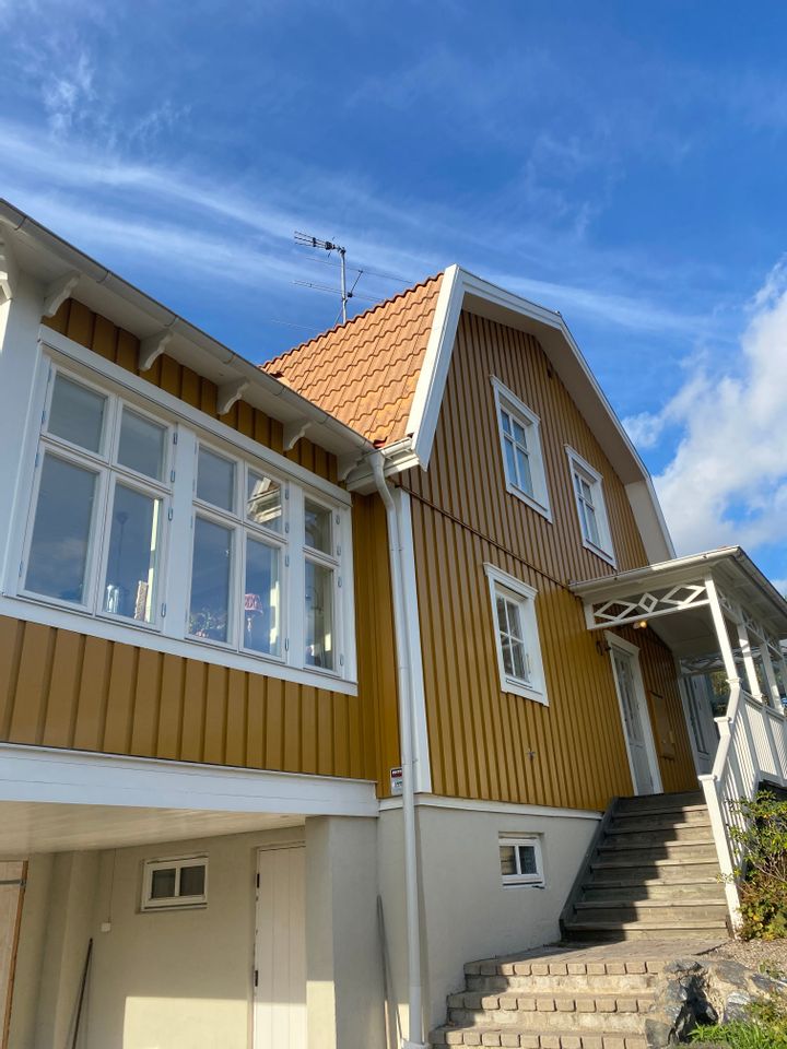 Ockragul träfasad med vita detaljer